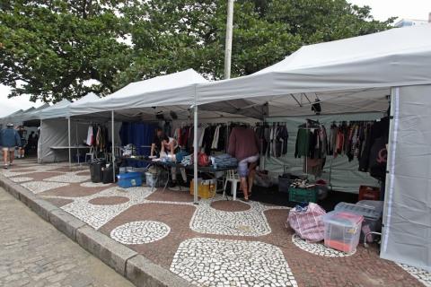 Barracas de apoio a produção estão montadas na área lateral do jardim da praia. #paratodosverem