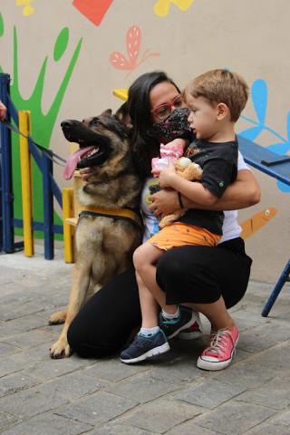 Mulher abraça cachorro e criança #paratodosverem