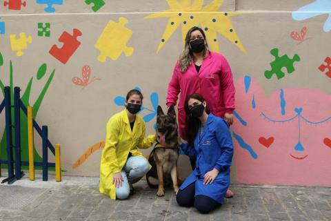Profissionais da clínica ao lado de cachorro posam para foto #paratodosverem