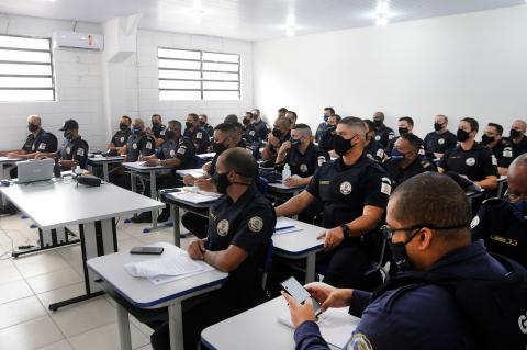 vários guardas uniformizados estão sentados em sala de aula. #paratodosverem