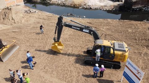 retroescavadeira em operação sobre terreno. #paratodosverem