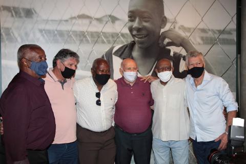 ídolos do Santos posam para foto: Lima, Manoel Maria, Edu, Pepe, Abel e Clodoaldo, com a foto de pelé menino ao fundo. #paratodosverem