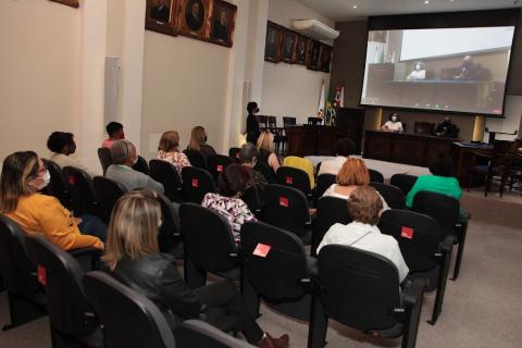 Pessoas no auditório acompanham palestra #paratodosverem