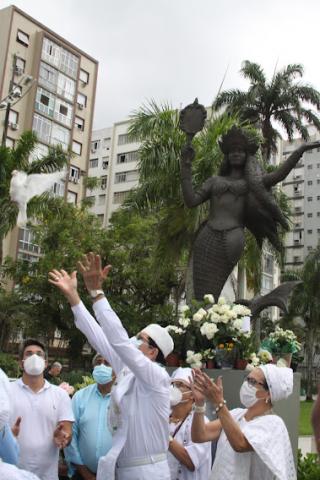 fieis soltam pomba branca diante de estátua da santa. #paratodosverem