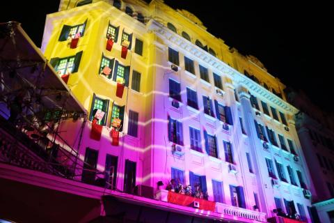 Fachada do hotel iluminada durante a apresentação. #paratodosverem