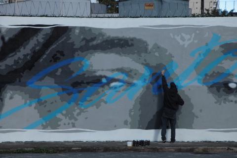 Artista grafita olhar de chorão em muro. #paratodosverem