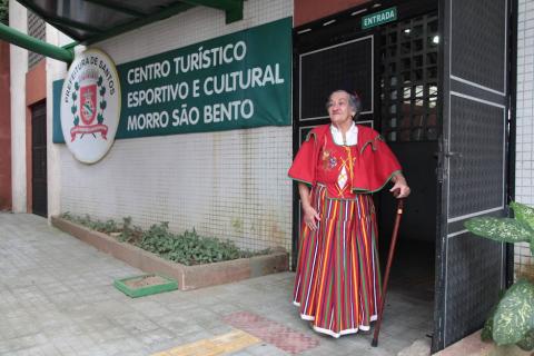 mulher com roupas típicas na porta de centro cultural #paratodosverem