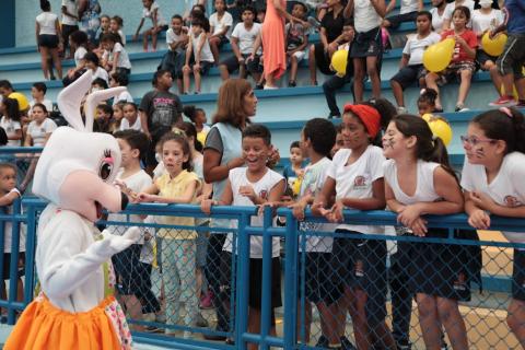 pessoa vestida de coelha conversa com crianças #paratodosverem