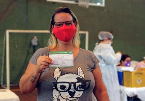 mulher mostra cartão de vacinação #paratodosverem