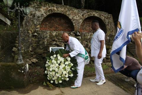 homem coloca coroa de flores junto a monumento