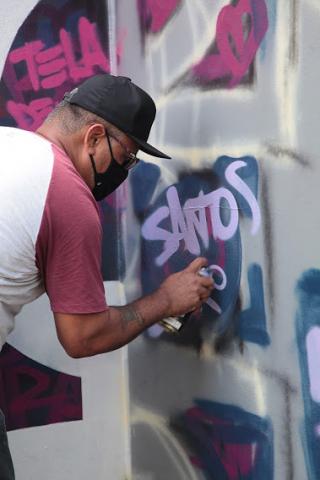 artista escreve santos em muro #paratodosverem 