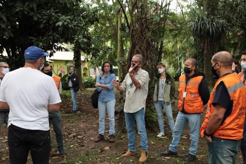 Profissionais estão conversando em área verde. #paratodosverem