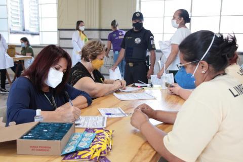 Várias pessoas sentadas em uma mesa fazendo anotações. #paratodosverem