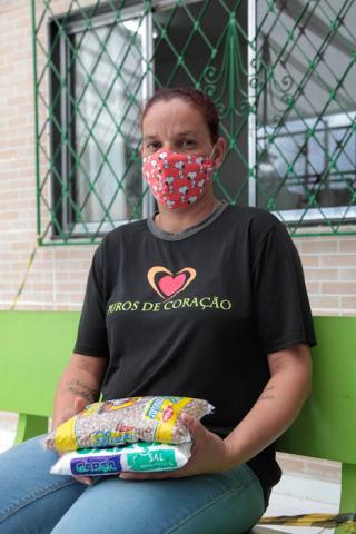 mulher segura sacos com alimentos #paratodosverem 