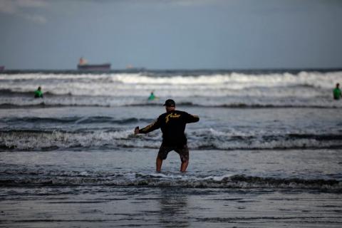 picutura faz movimento de surfe na areia #paratodosverem