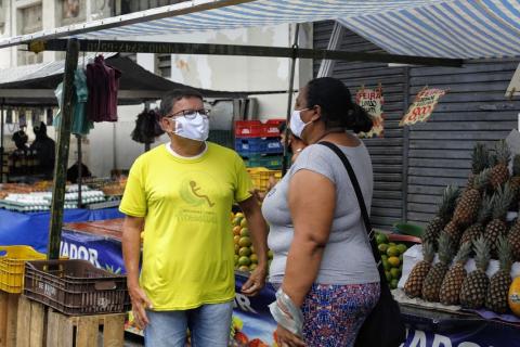 homem fala com mulher em frente a barraca #paratodosverem 