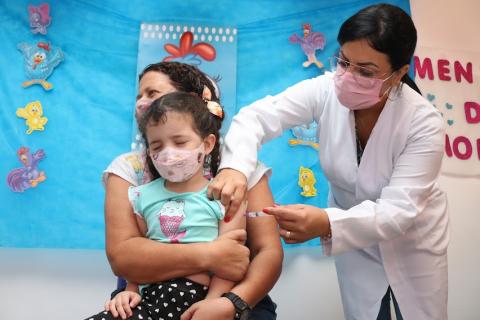 menina é vacinada no  braço #paratodosverem