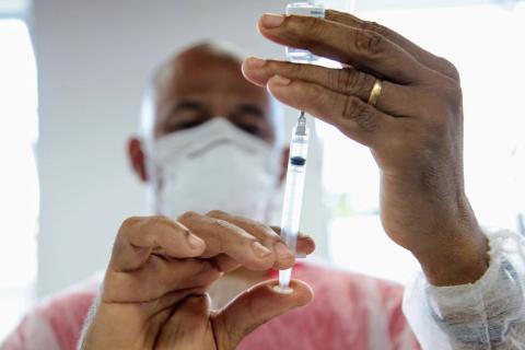 profissional coloca vacina em seringa #paratodosverem 