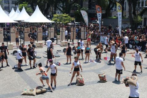 Atletas realizam atividades na Praça Mauá, sob forte sol e acompanhados por grande público. #pracegover