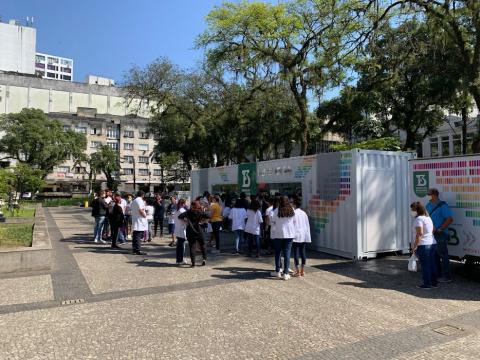 Estudantes observam laboratório dentro do container #paratodosverem