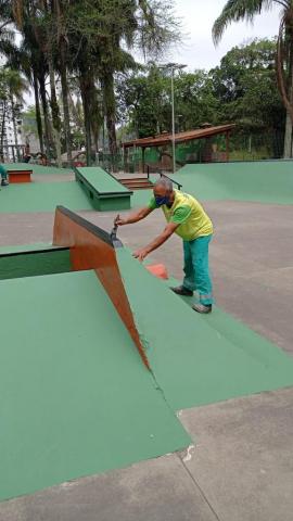 Homem pinta trecho de pista de skate. #paratodosverem