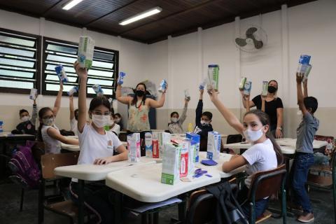 Estudantes levantam caixas de leite na sala de aula #paratodosverem