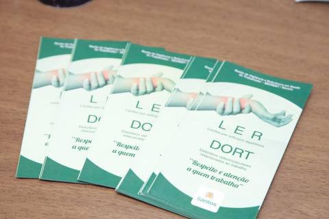 folders sobre uma mesa com informações sobre LER E DORT