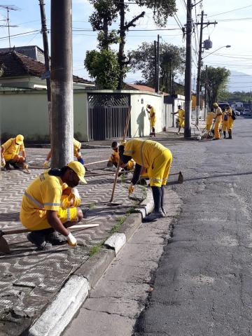 Homens realizando limpeza em via. #paratodosverem