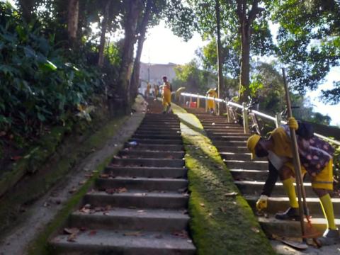 Homens realizando limpeza em escadaria do morro. #paratodosverem