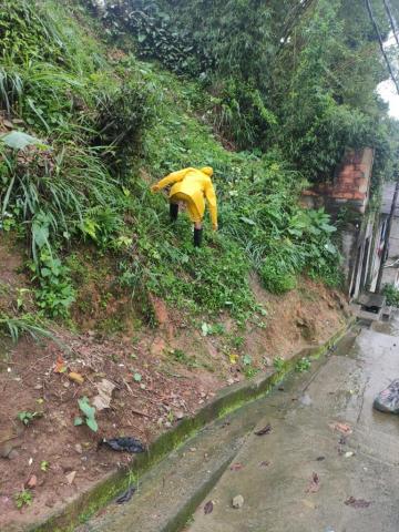 Homem realiza limpeza em área da encosta de morro #paratodosverem