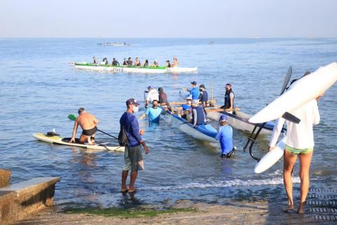 Ação envolveu participantes de canoagem. Várias canoas estão no mar. #paratodosverem 