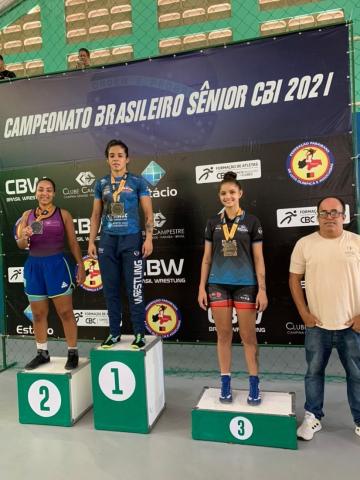 Atletas no pódio com medalhas #paratodosverem