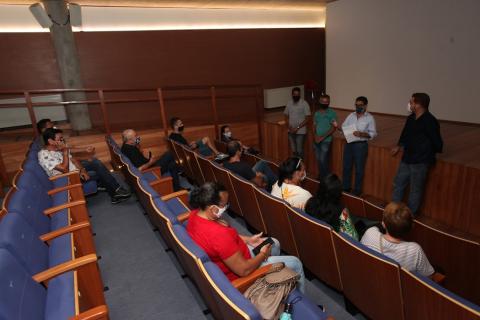 pessoas ouvem orientações no auditório #paratodosverem