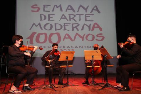 quatro músicos se apresentando no palco #paratodosverem