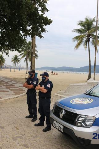 dois guardas parados na orla #paratodosverem 