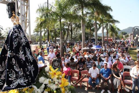 público acompanha a missa na frente de imagem de santa #paratodosverem