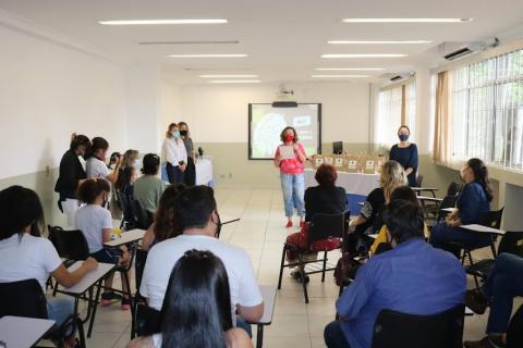 Sala com várias pessoas e pessoa falando a frente #paratodosverem