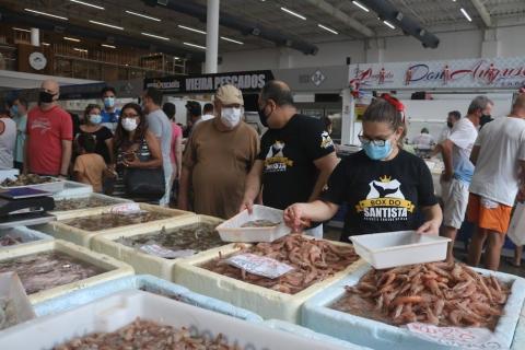 boxes com pescados, camarão predominantemente, público circula em torno. #paratodosverem