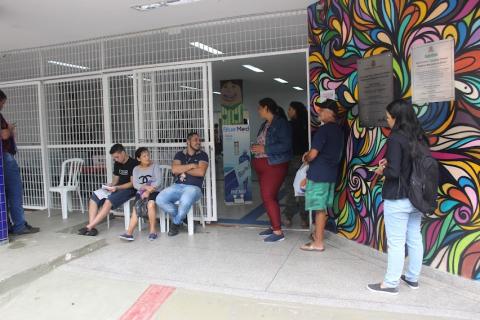 porta de entrada da vila criativa, com pessoas sentadas e em pé. #paratodosverem