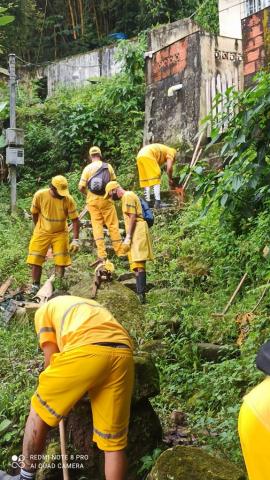 trabalhadores realizam limpeza em encosta do morro #paratodosverem