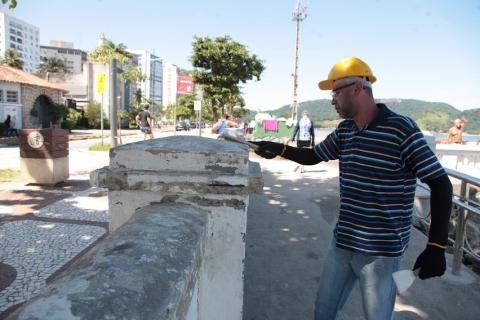 homem pinta trecho de mureta. #paratodosverem