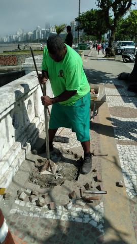 homem trabalha no piso da calçada da orla #paratodosverem