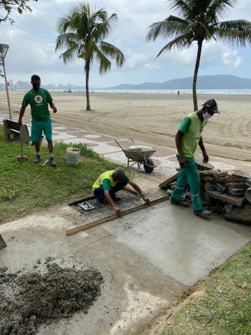 homens fazem reparos em piso do jardim da orla. #paratodosverem