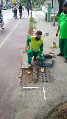 homens fazem reparo junto à trecho de ciclovia. #paratodosverem