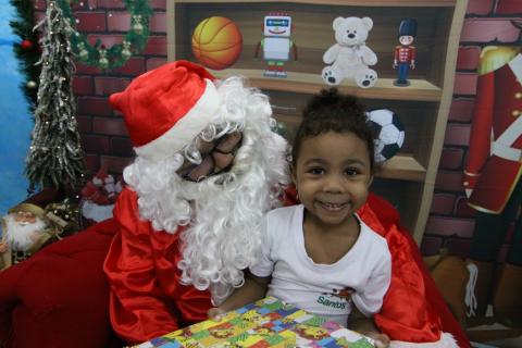 criança sorri no colo do papai noel  #paratodosverem