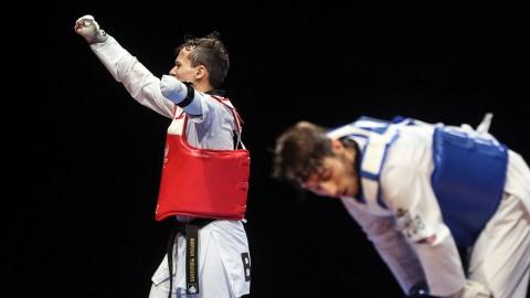 nathan celebra vitória com os braços para o alto. Atrás, o adversário com o tronco inclinado para baixo. #paratodosverem