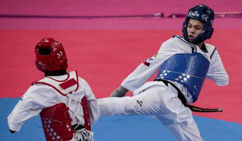 nathan em plena luta, lançando chute com a perna direita no abdome de adversário. #paratodosverem