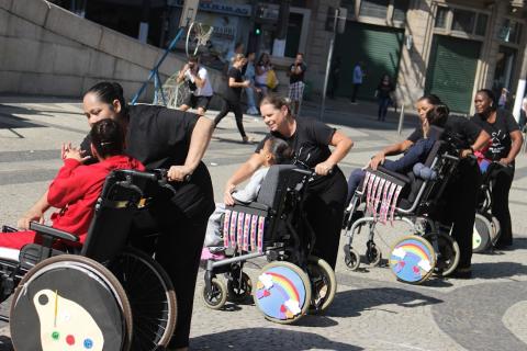 cadeirantes ao lado de pessoas segurando a cadeira #paratodosverem