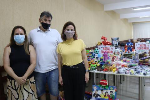 três pessoas posam para foto ao lado dos brinquedos #paratodosverem