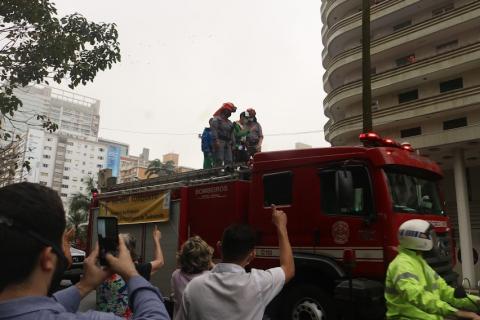 Público tira fotografias do atleta no alto do carro do Bombeiros. #pracegover